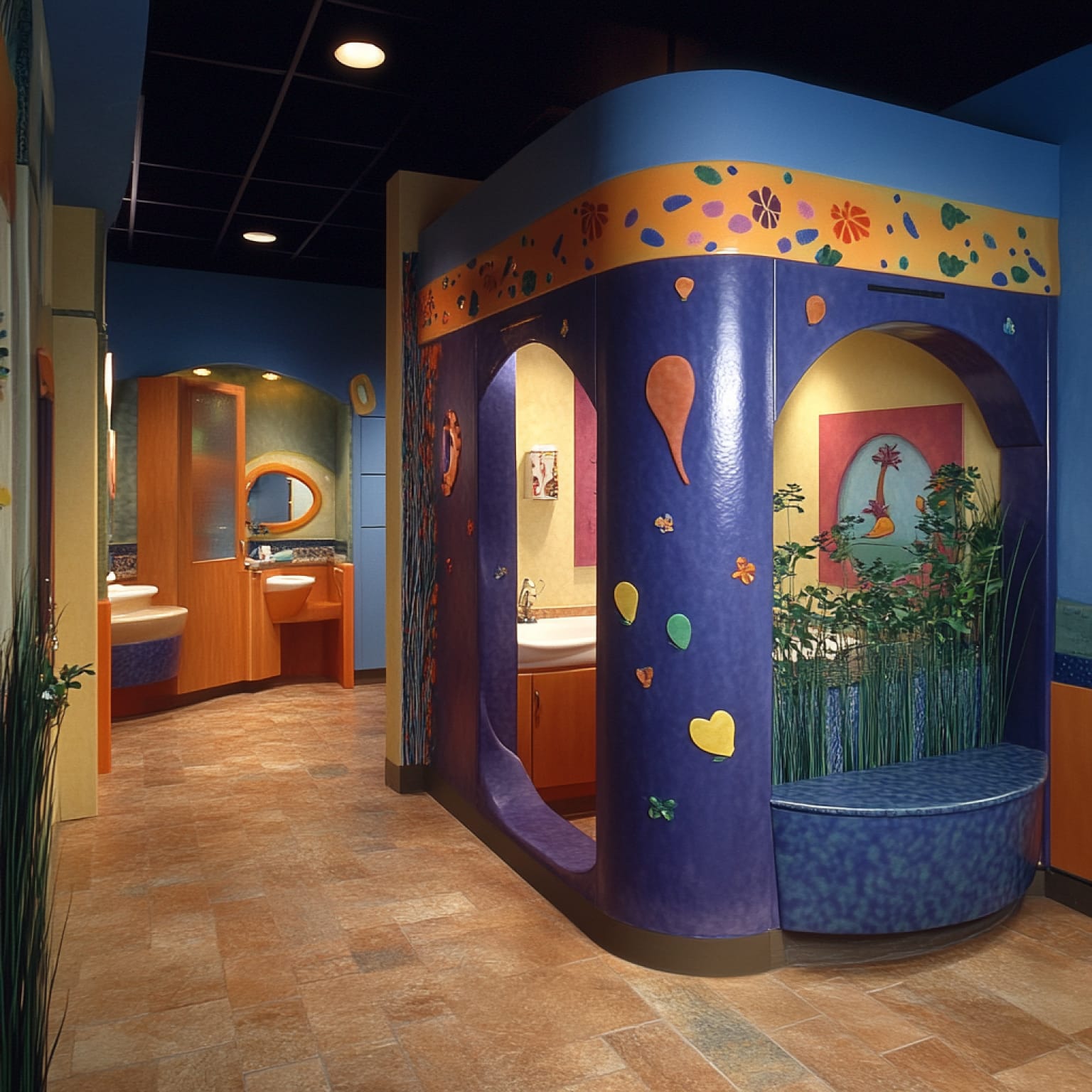 Colorful children's dentist office features playful decor, bright murals, and curved walls, creating an inviting atmosphere with plants and whimsical design elements.